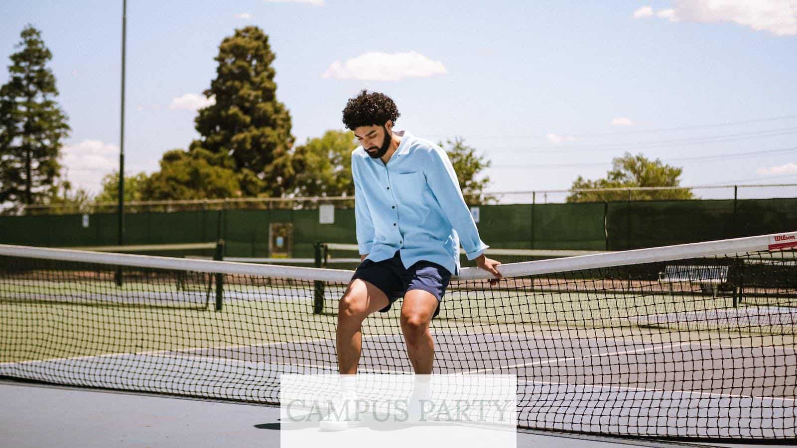 Man Sitting on Tenis Court Net