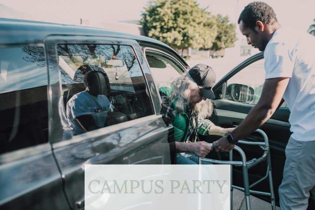 Man in White Shirt Helping an Elderly Person