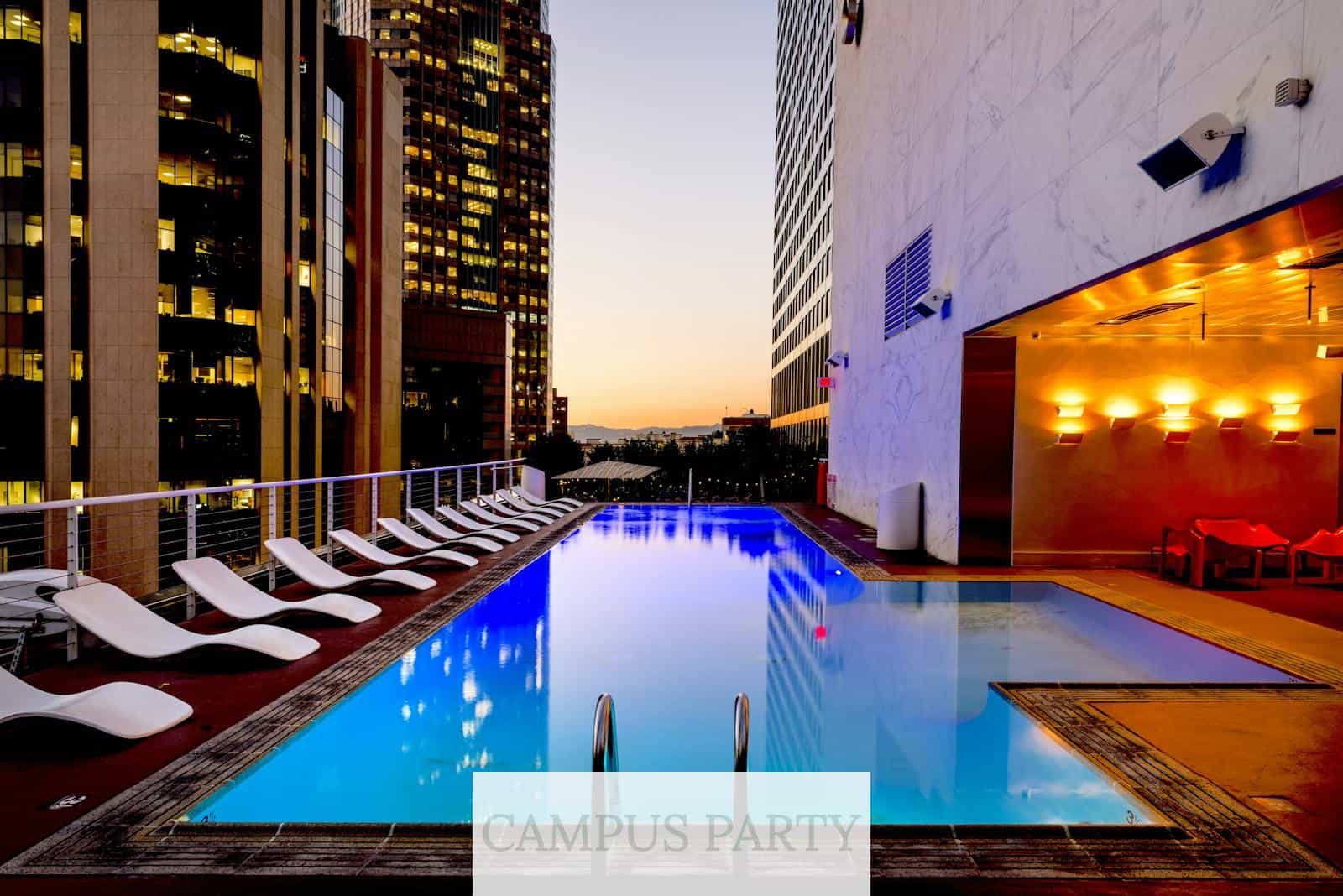 Elegant rooftop pool with cityscape backdrop at sunset, reflecting urban luxury.