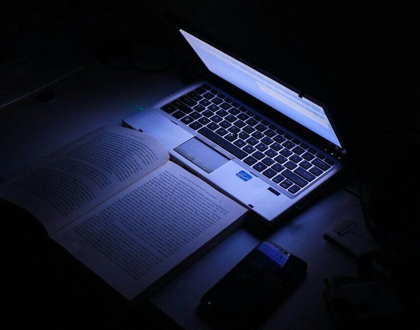 Portátil abierto con la pantalla encendida en una habitación a oscuras